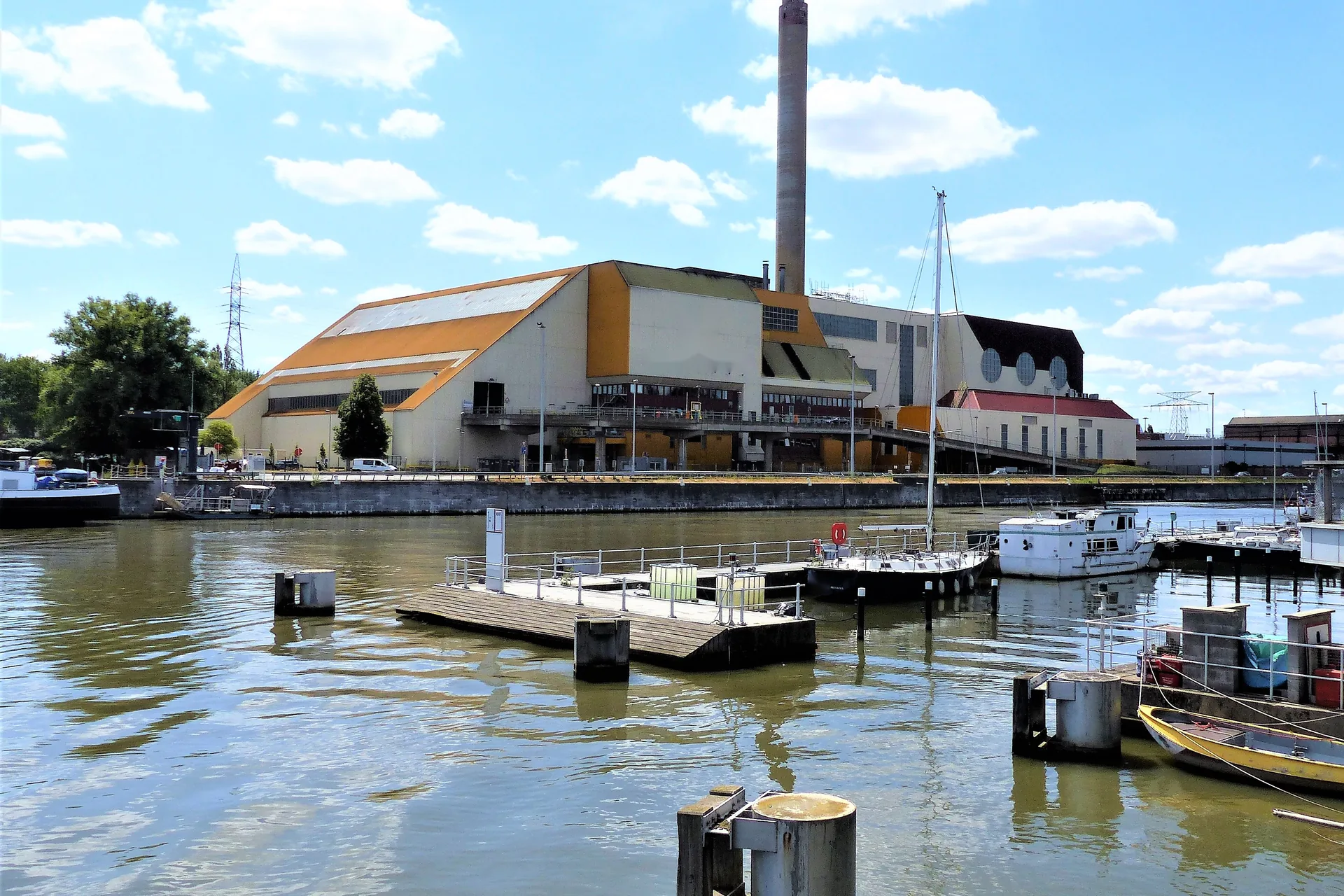 Grand hall industriel avec haute cheminée au bord du canal à Bruxelles, vu depuis le port de plaisance